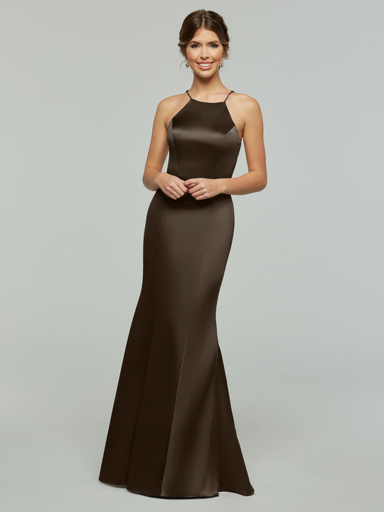 A woman smiles in the Avery Austin TH-80071, a sleek, sleeveless, floor-length dark brown satin gown with a fitted bodice and flared skirt, standing against a plain light gray background.