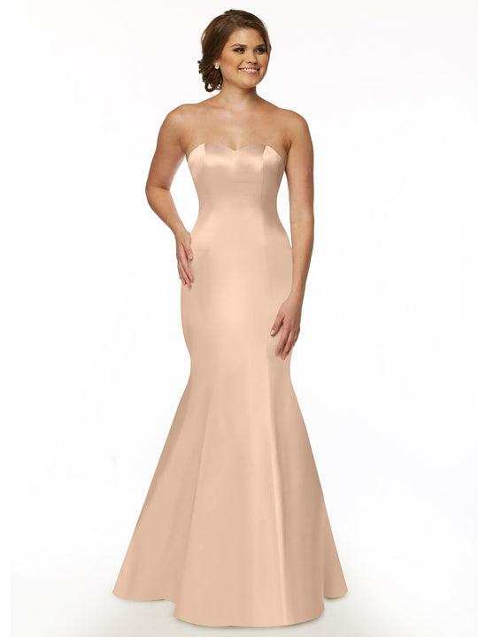 A woman smiles against a plain white background wearing the Avery Austin TH-80072 strapless satin mermaid bridesmaid dress in blush.