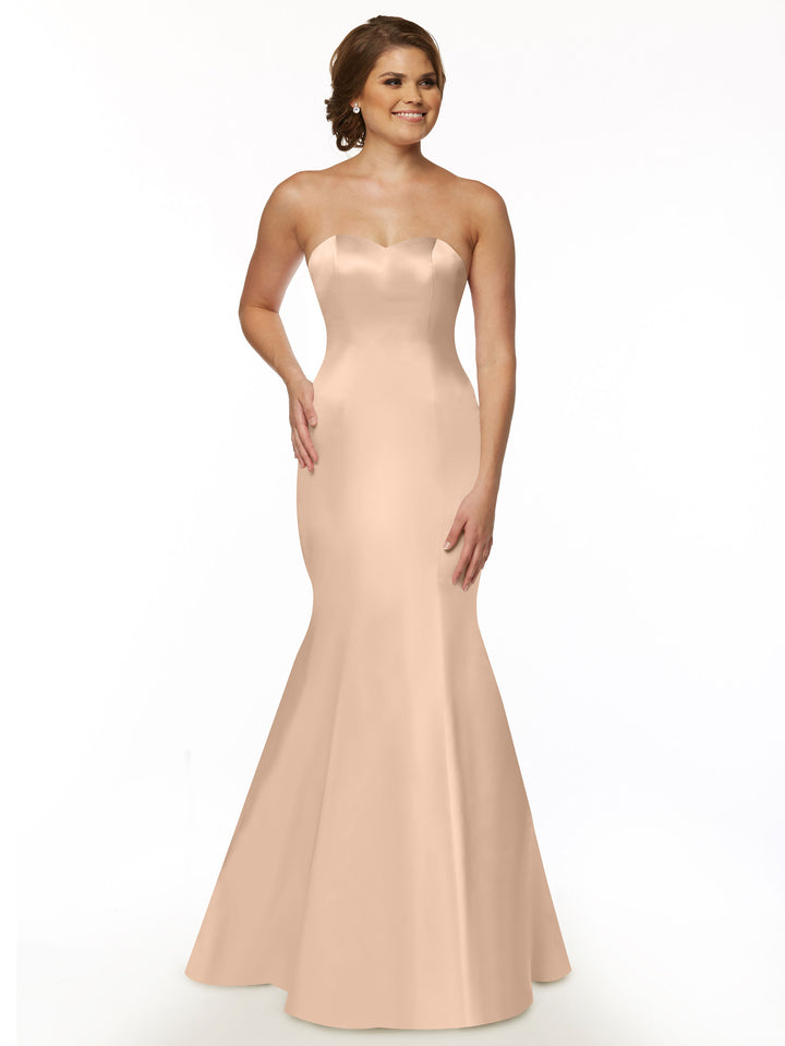 A woman smiles against a plain white background wearing the Avery Austin TH-80072 strapless satin mermaid bridesmaid dress in blush.