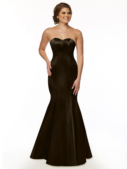 A woman smiles with one hand on her hip, wearing the Avery Austin 80072 strapless black floor-length mermaid bridesmaid dress against a plain white background.