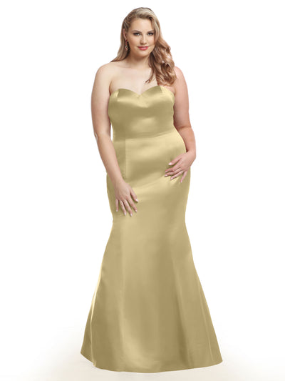 A woman with long, wavy blonde hair models the Avery Austin 80072 gown in Palomino. This strapless, fitted mermaid dress features a sweetheart neckline. She poses against a plain white background, smiling with one hand on her hip.