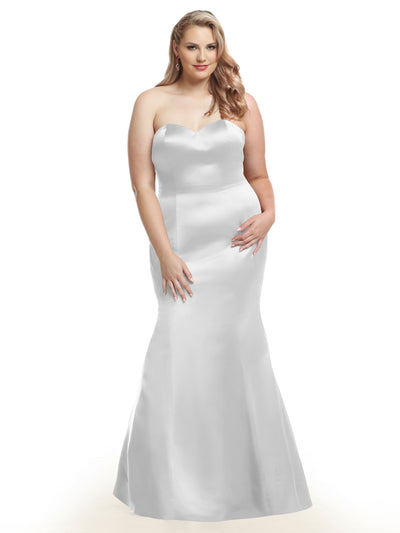 A woman wears Avery Austin’s 80072: a silver strapless, sweetheart neckline, floor-length fit and flare dress with a fitted bodice and flared skirt, standing against a plain white background.
