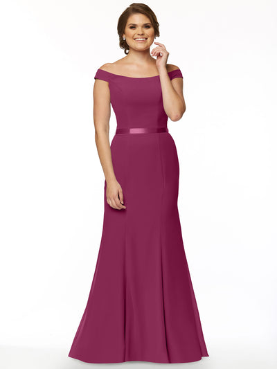 A woman smiles against a plain white background wearing Avery Austin's floor-length, magenta fit-and-flare bridesmaid dress (style 80079) with an off-the-shoulder neckline, fitted bodice, and flared skirt.