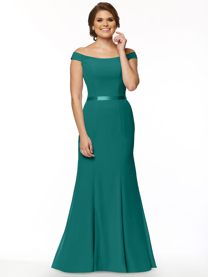 A woman models the Avery Austin 80079, an off-the-shoulder teal bridesmaid dress with a fitted bodice and flared, floor-length skirt, smiling as she stands against a plain white background.