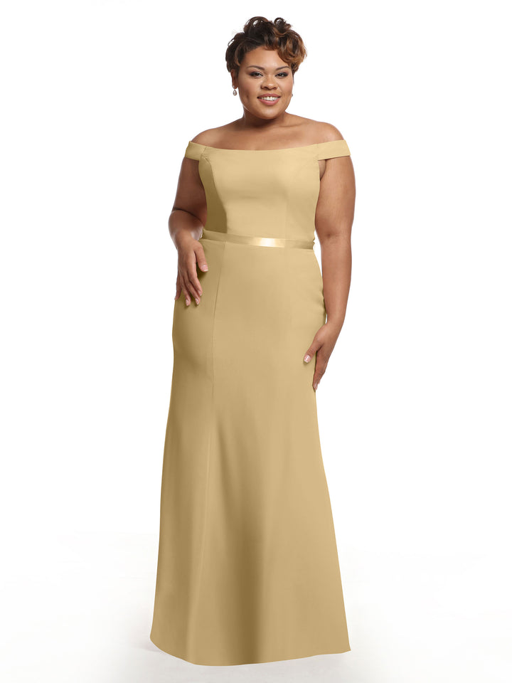A woman in the Avery Austin 80079 champagne off-the-shoulder bridesmaid dress with a fitted waist smiles against a plain white background.