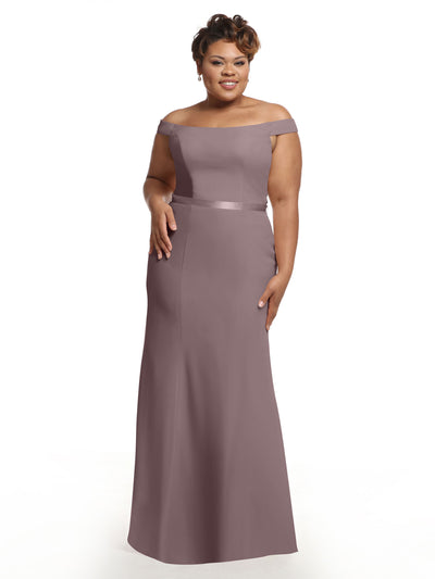 A woman stands and smiles against a plain white background, wearing the Avery Austin 80079 off-the-shoulder chiffon bridesmaid dress in mauve.