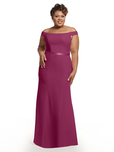 A woman models Avery Austin style 80079, an off-the-shoulder magenta bridesmaid dress with a fitted waist and floor-length fit-and-flare silhouette, smiling as she stands against a plain white background.