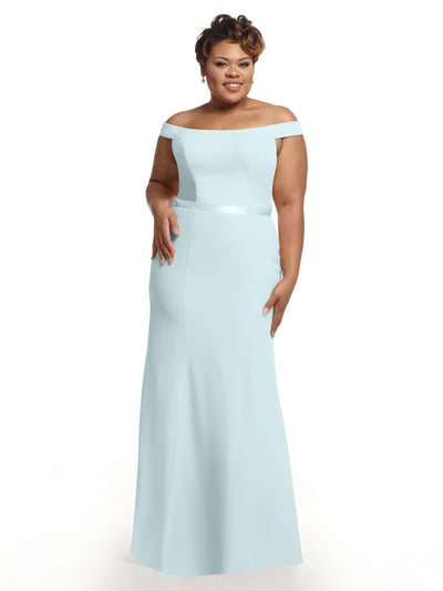A woman wearing Avery Austin’s 80079 light blue, off-the-shoulder bridesmaid dress smiles against a plain white background.