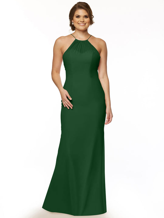 A woman models Avery Austin’s 80083, a sleeveless floor-length dark green chiffon halter dress with a keyhole back, smiling with one hand on her hip against a plain white background.