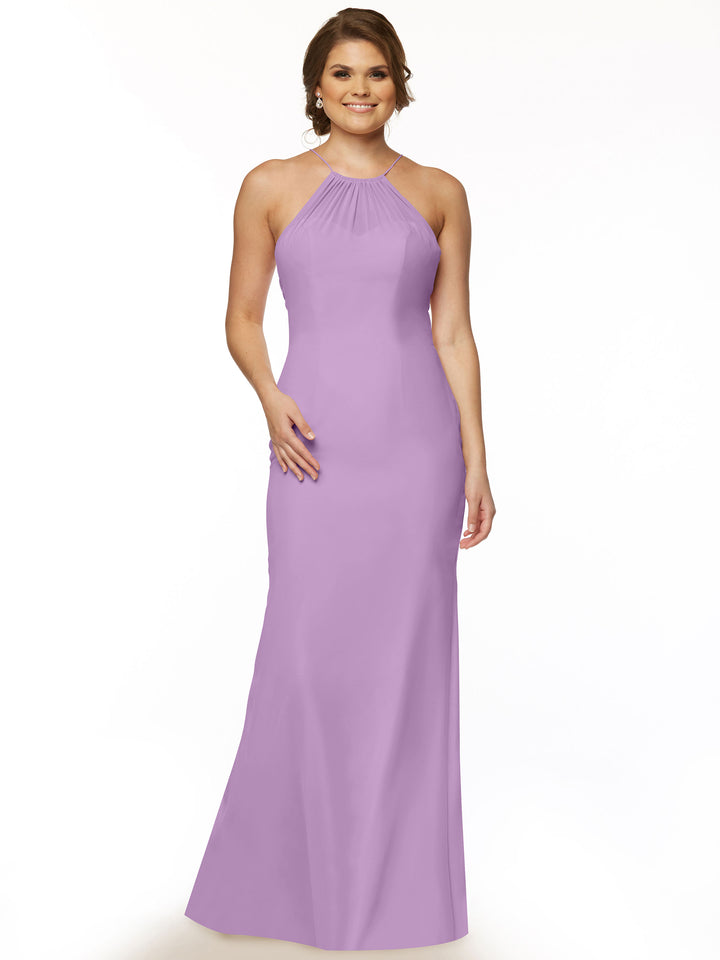 A woman smiles in the Avery Austin TH-80083, a lavender chiffon halter dress with a floor-length skirt and keyhole back. She has light brown wavy hair, wears simple jewelry, and stands against a plain white background.
