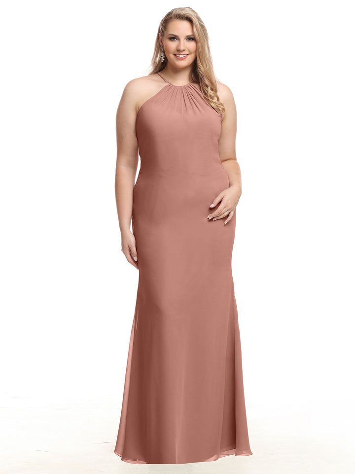 A woman smiles against a plain white background wearing Avery Austin style 80083—a sleeveless, floor-length dusty rose chiffon halter dress with a keyhole back.