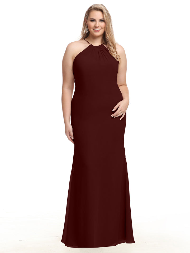 A woman with long blonde hair smiles while modeling the Avery Austin 80083 dress in Merlot, a sleeveless, floor-length chiffon gown with a high neckline, standing against a plain white background.