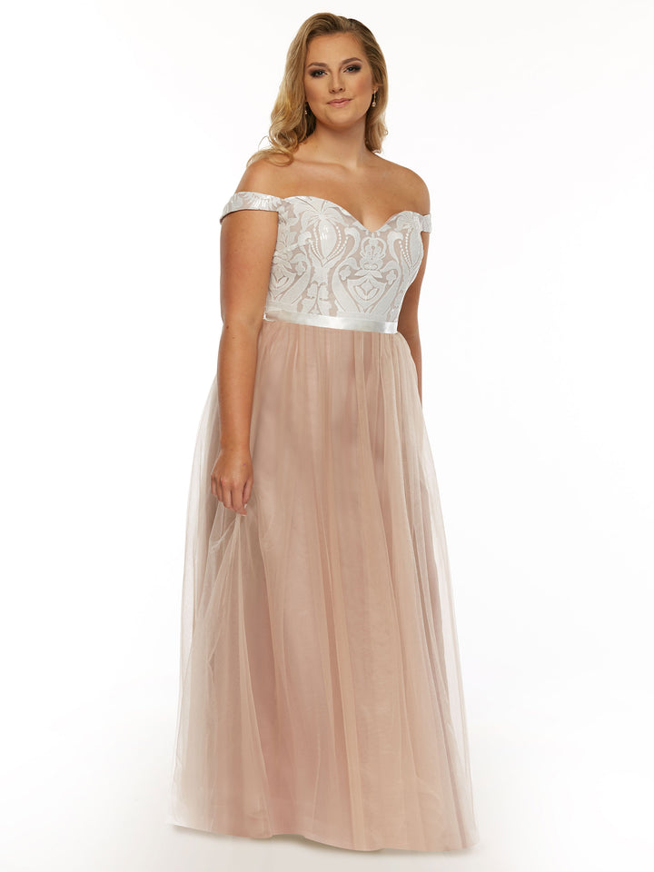 A woman models the Avery Austin TH-80085 gown in Buff/Ivory, featuring an off-the-shoulder lace design with a fitted embroidered bodice and flowing tulle A-line skirt, standing against a plain white background and smiling slightly.