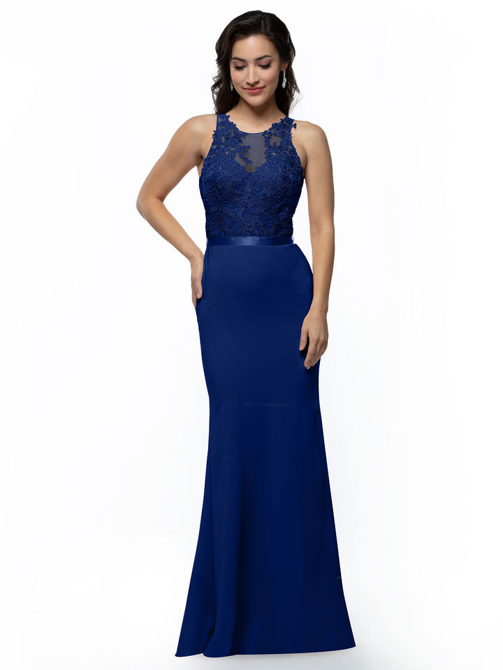 A woman in Avery Austin’s 80095 sleeveless royal blue evening gown with an illusion neckline and lace accents stands against a white background, smiling softly.