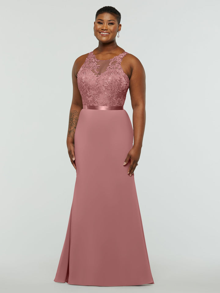 A woman smiles in Avery Austin’s 80095—a sleeveless, floor-length dusty rose chiffon bridesmaid dress with lace bodice, satin waistband, and smooth skirt—standing against a plain light background.
