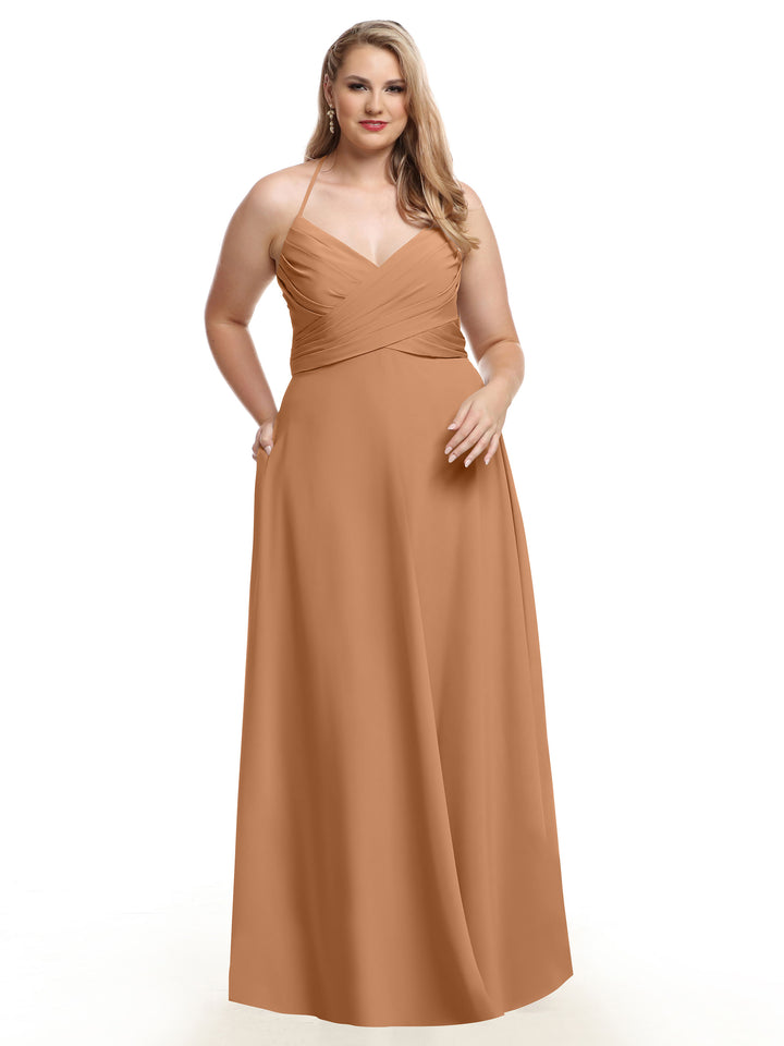 A woman with long blonde hair models the Avery Austin 80101 floor-length light brown A-Line dress with a V-neck and pleated bodice, standing against a plain white background.