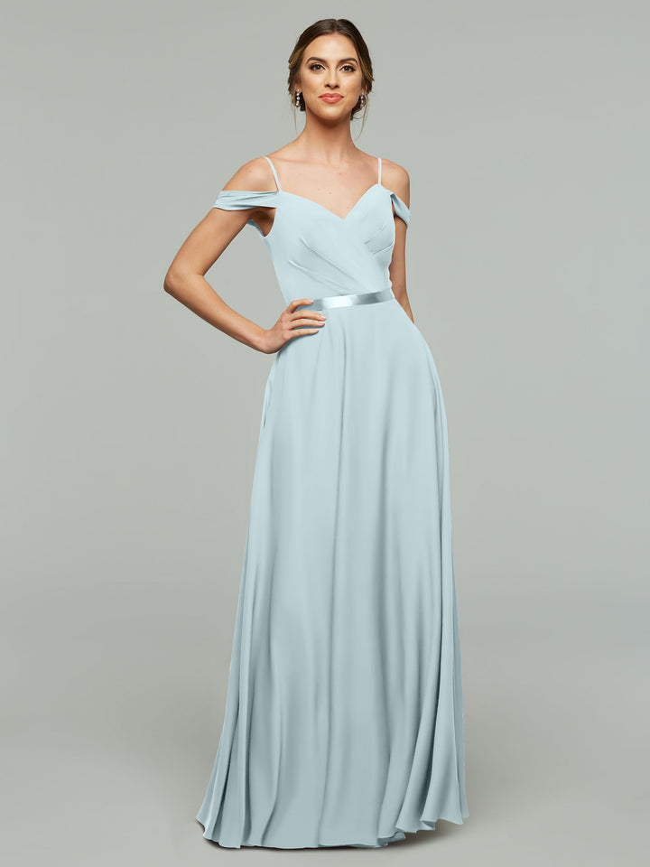 A woman poses with one hand on her hip against a gray background wearing the Avery Austin TH-80106, a sky blue off-the-shoulder chiffon bridesmaid dress with spaghetti straps and a fitted bodice.