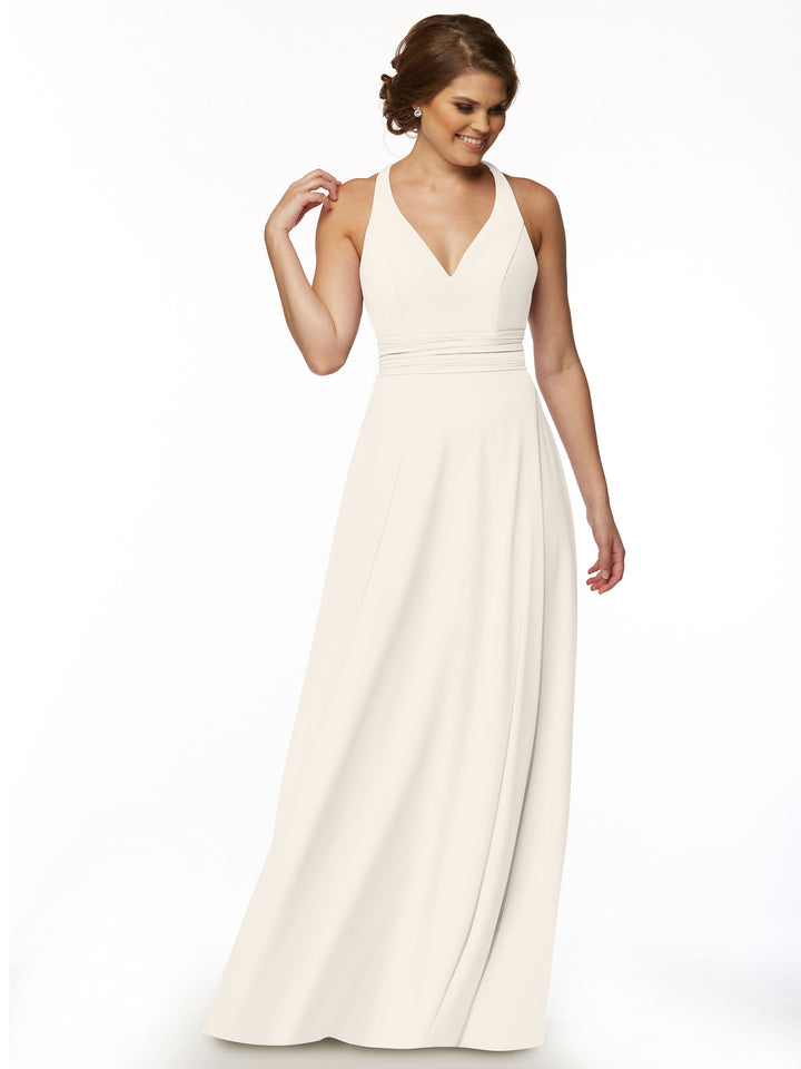 A woman smiles and looks to the side, wearing Avery Austin’s 80107—a sleeveless, floor-length ivory A-line dress with a deep V-neckline and fitted waist—set against a plain white backdrop for a soft, feminine look.