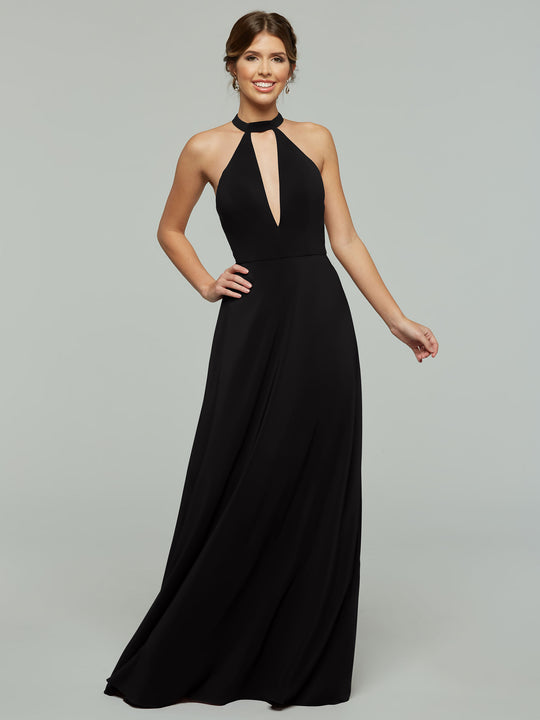 A woman wears Avery Austin’s 80115: a sleeveless, floor-length black halter A-line dress with a front keyhole cutout, standing and smiling against a plain light gray background.