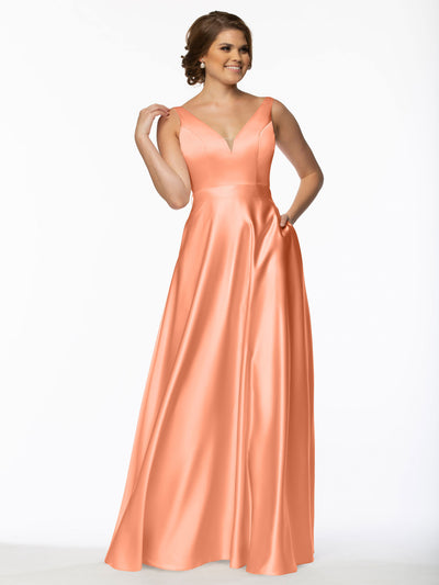 A woman smiles in the Avery Austin 80118, a floor-length satin bridesmaid dress with a deep V-neckline. Posing against a plain white background, she gracefully holds her hair, highlighting the elegant style of this long gown.