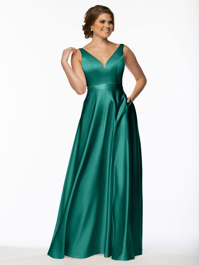 A smiling woman poses against a white background wearing Avery Austin's Product 80118, a sleeveless, floor-length emerald green satin bridesmaid dress featuring a V-neckline and pockets.