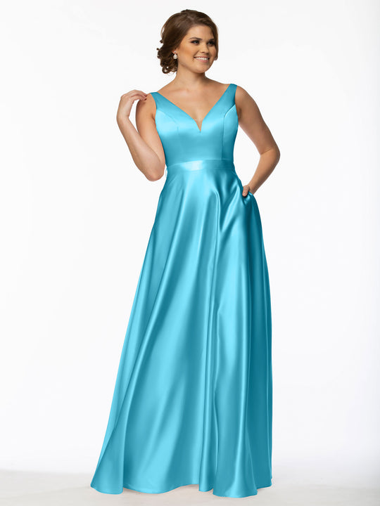 A woman in the Avery Austin 80118 sleeveless floor-length turquoise bridesmaid dress with pockets and a V-neckline stands smiling against a white background, holding a section of her hair.