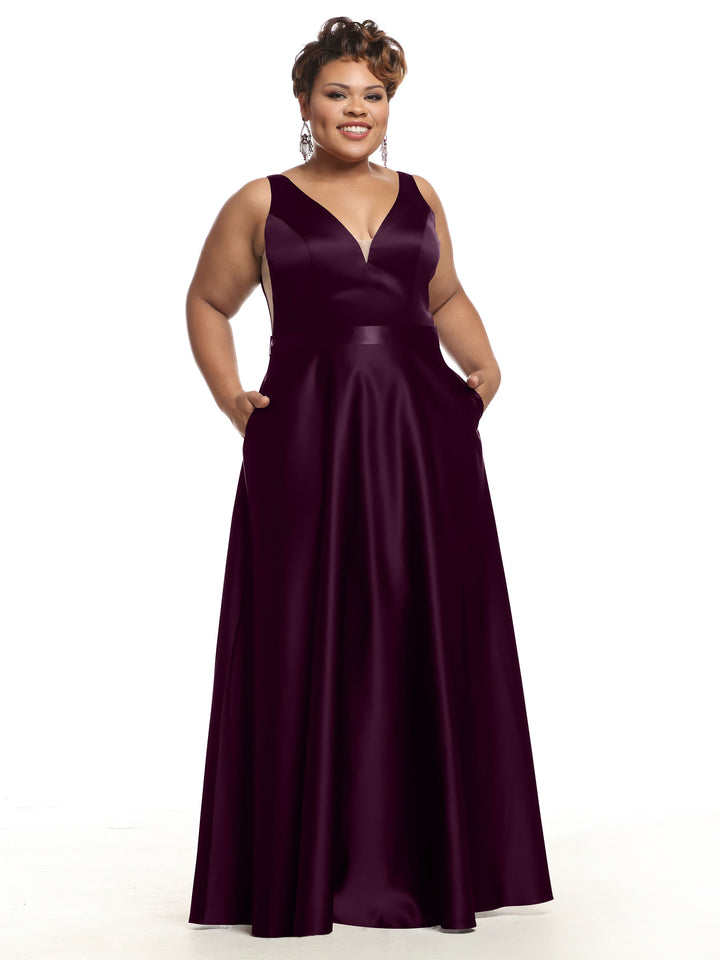 A woman models the Avery Austin TH-80118, a sleeveless floor-length satin bridesmaid dress with V-neckline and pockets, smiling against a white background.
