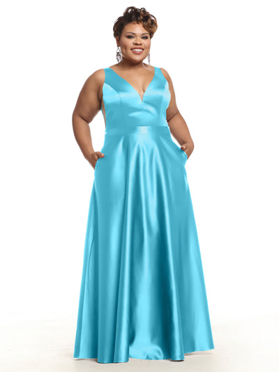 A woman smiles in Avery Austin style 80118, a sleeveless turquoise satin bridesmaid dress with a deep V-neckline and pockets. The long gown drapes gracefully to the floor as she poses against a white background.