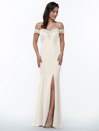 A woman in Avery Austin's 80121 ivory chiffon off-the-shoulder bridesmaid dress, featuring lace details and a front slit, stands against a white background and looks down with a slight smile.