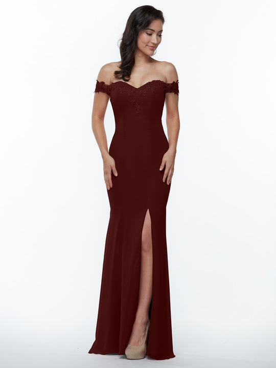 A woman in the Avery Austin TH-80121 floor-length burgundy off-the-shoulder bridesmaid dress with a thigh-high slit and lace neckline, paired with beige heels, poses against a plain white background.