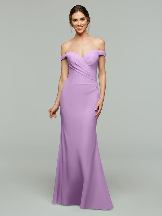 A woman smiles against a light gray background in the Avery Austin TH-80122, a lilac floor-length, off-the-shoulder bridesmaid dress with a fitted sweetheart bodice and subtle draping.