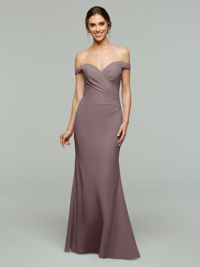 A woman smiles against a gray background wearing the Avery Austin 80122, a mauve off-the-shoulder bridesmaid dress with a sweetheart neckline. This elegant floor-length gown is an ideal choice for any bridal party.