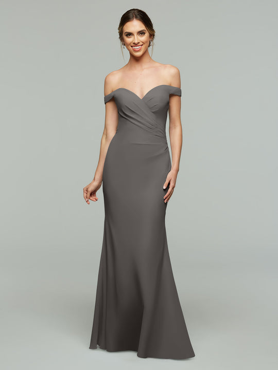 A woman models Avery Austin’s 80122—a floor-length, off-the-shoulder gray bridesmaid dress with a fitted silhouette, sweetheart neckline, gently ruched bodice, and her hair styled in a loose updo.