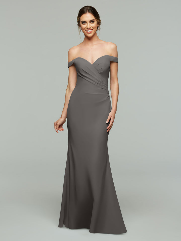 A woman models Avery Austin’s 80122—a floor-length, off-the-shoulder gray bridesmaid dress with a fitted silhouette, sweetheart neckline, gently ruched bodice, and her hair styled in a loose updo.