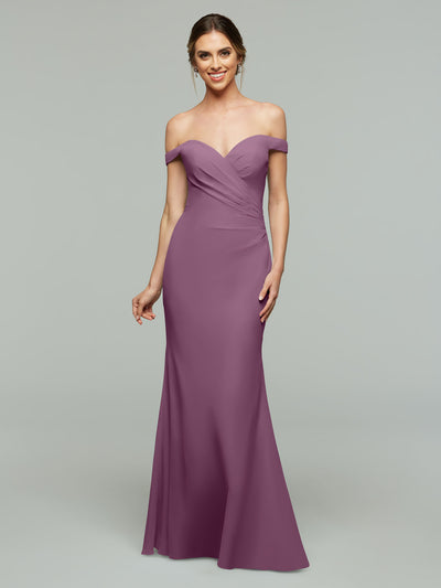 A woman smiles in the Avery Austin 80122 mauve off-the-shoulder bridesmaid dress, featuring a fitted bodice and flared skirt, set against a plain gray background.
