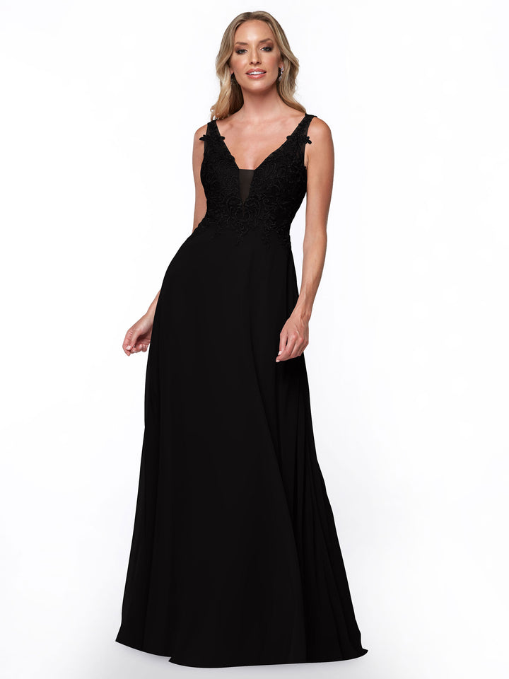 A woman with light hair smiles slightly while modeling Avery Austin’s black bridesmaid dress (style 80128), featuring a fitted lace bodice and a flowing chiffon skirt against a white background.