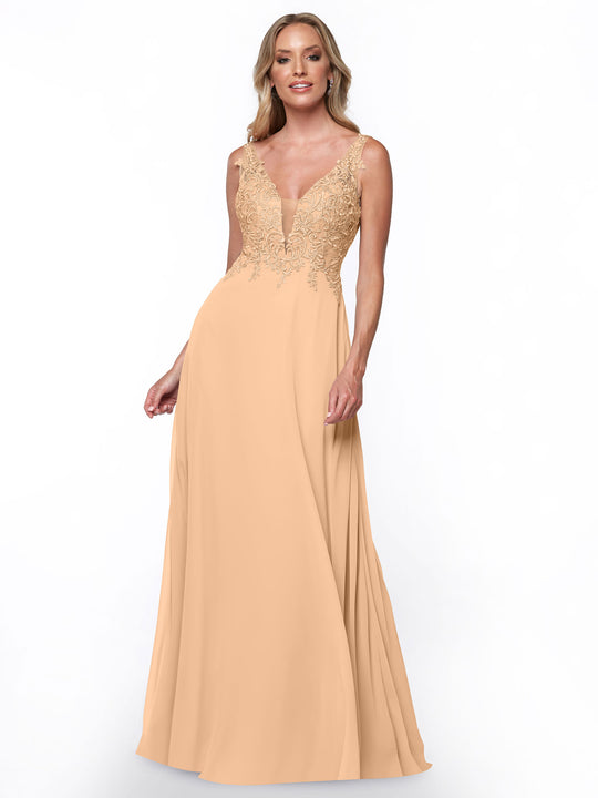 A woman wearing Avery Austin's 80128, a floor-length chiffon bridesmaid dress with a deep V-neckline and lace bodice, stands against a plain white background, smiling slightly.