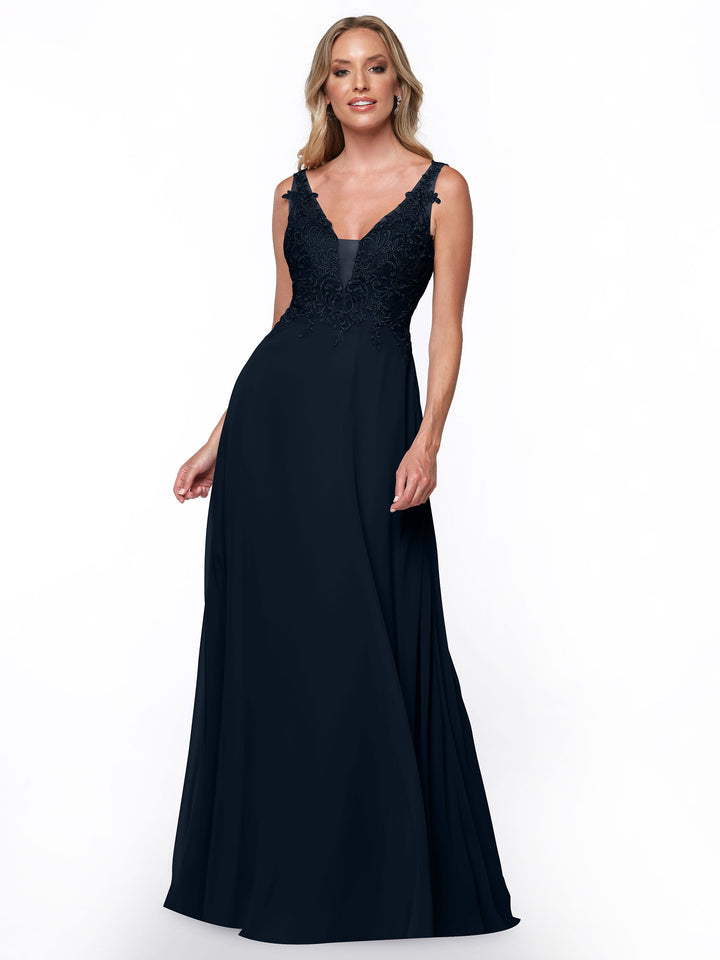 A woman models Avery Austin’s midnight 80128—a sleeveless, floor-length chiffon bridesmaid dress with a lace bodice and V-neckline—standing against a plain white background.