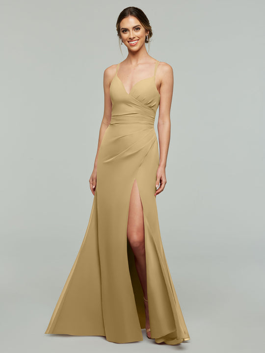 A woman wearing Avery Austin style 80130, a champagne sleeveless sheath bridesmaid dress with thin straps, thigh-high slit, and fitted bodice, stands smiling against a plain light gray background.