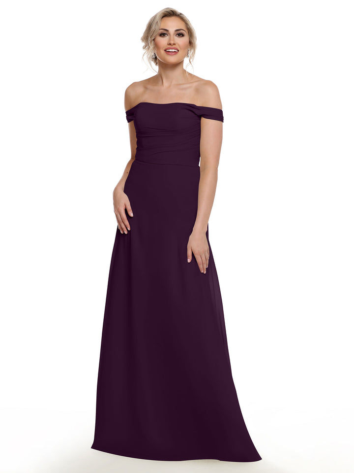 A woman in Avery Austin’s 80136 off-the-shoulder, floor-length dark purple chiffon dress smiles against a plain white background.