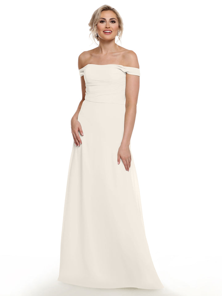 A woman stands smiling against a plain white background, wearing Avery Austin&