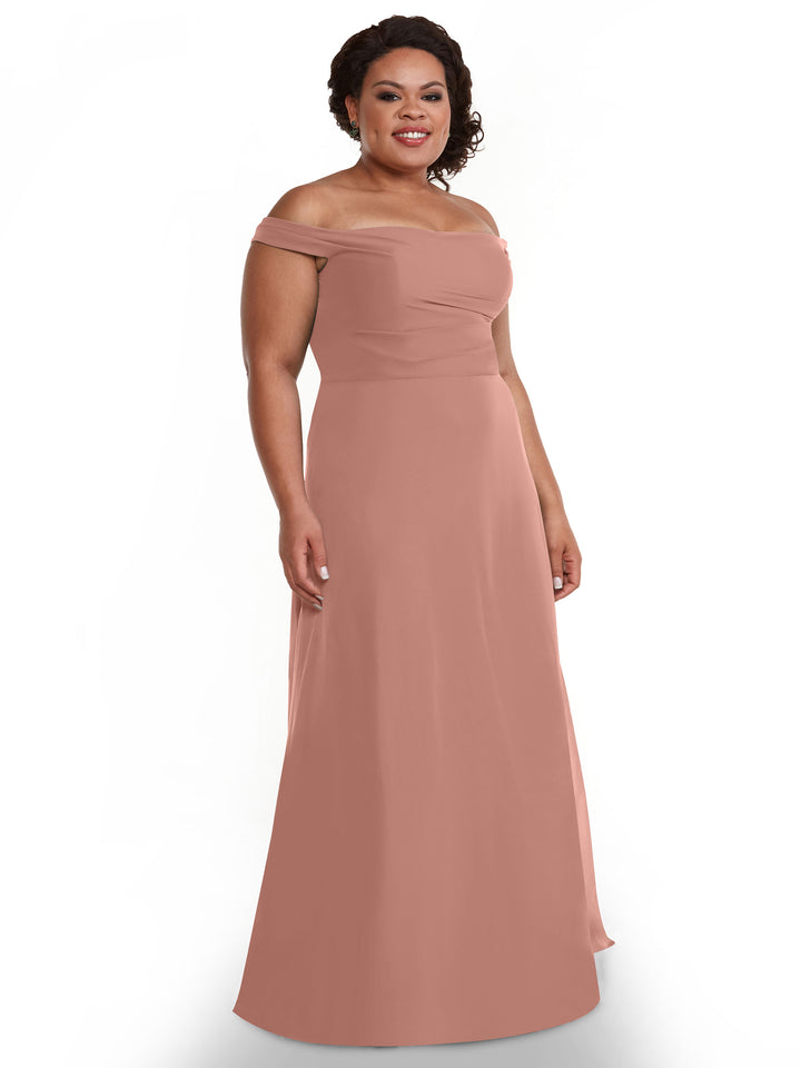 A woman in Avery Austin style 80136, a rose off-the-shoulder chiffon dress, smiles against a plain white background.