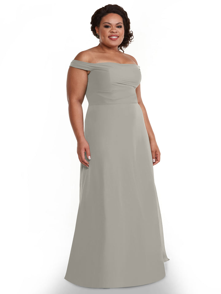 A woman smiles in Avery Austin’s 80136 dress—an off-the-shoulder, floor-length light gray chiffon gown with a fitted bodice and flowing skirt, set against a plain white background.