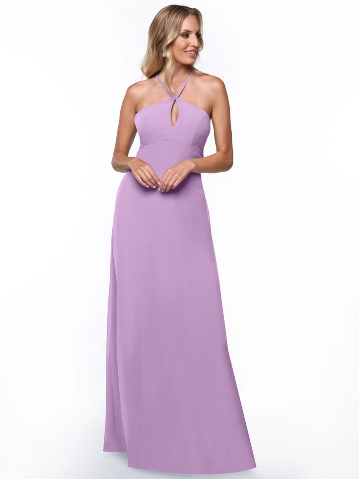 A woman with long, wavy blonde hair smiles gently while modeling Avery Austin’s floor-length, sleeveless lavender halter dress (style 80137) featuring a keyhole cutout against a plain white background, showcasing an elegant minimalist look.