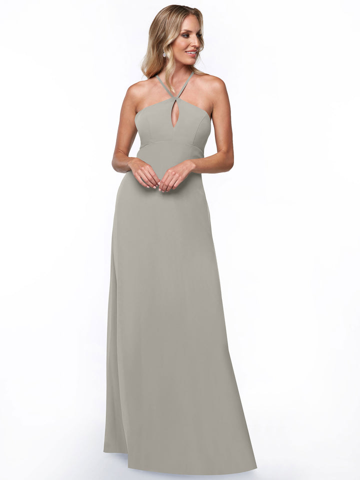 A woman smiles and looks to the side, wearing the Avery Austin TH-80137 halter dress in silver with a keyhole neckline, standing against a plain white background.