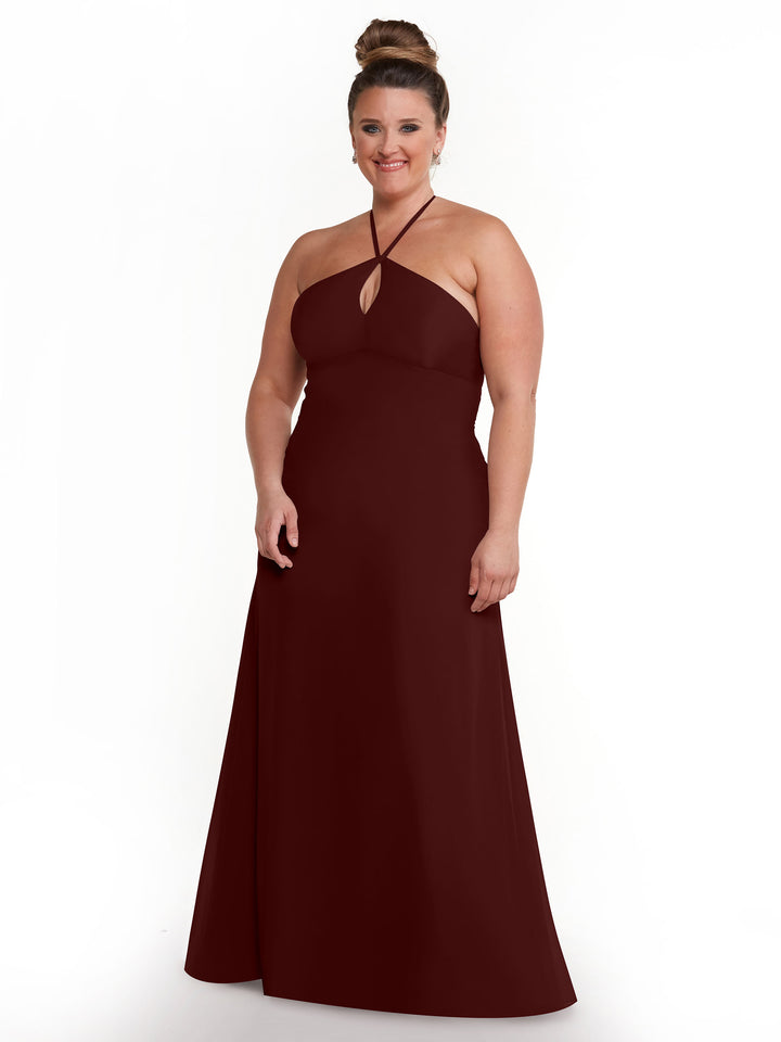 A woman stands smiling against a white background, wearing Avery Austin&