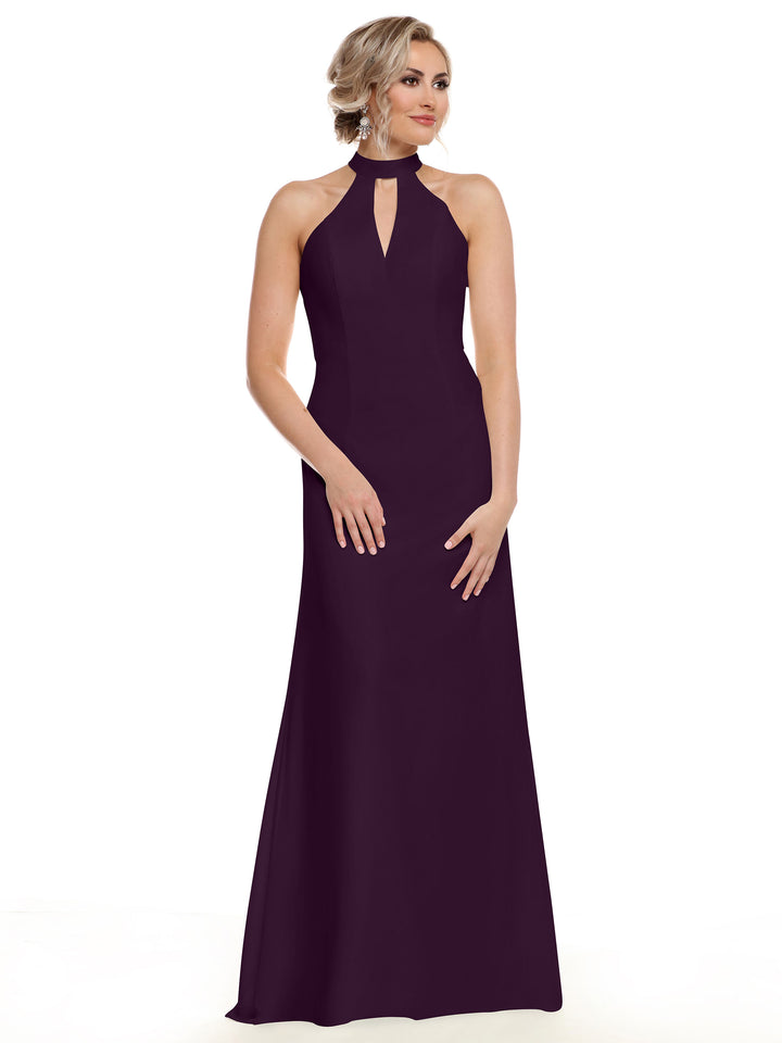 A woman in Avery Austin’s 80138, a sleeveless floor-length dark purple gown with a halter neckline and front keyhole cutout, stands against a white background. Her light hair is styled in an updo and she has a neutral expression.