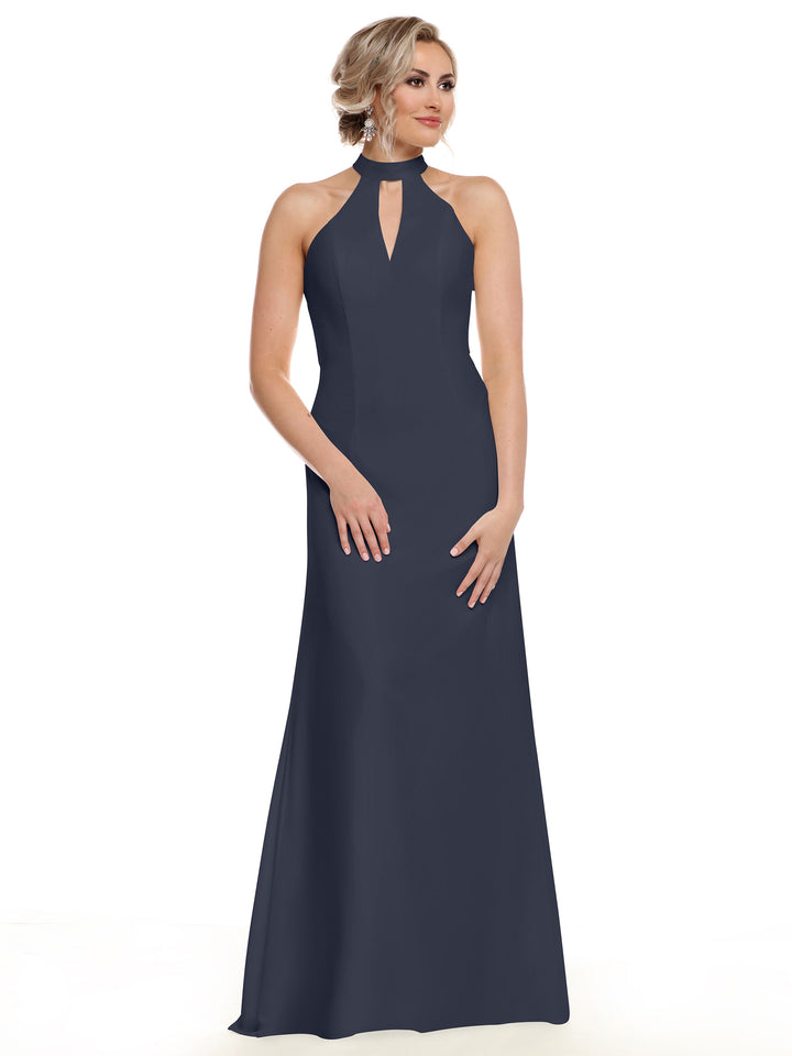 A woman showcases Avery Austin’s Floor-Length Halter Gown 80138 in navy blue, featuring a sleeveless design and front keyhole cutout, standing against a white background.