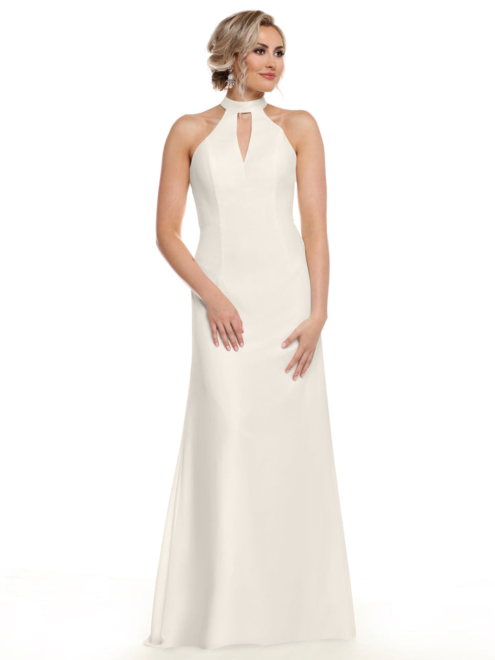 A woman wears the Avery Austin TH-80138, a sleeveless, floor-length white gown with a halter neckline and keyhole cutout, standing against a plain white background to highlight your shoulders elegantly.