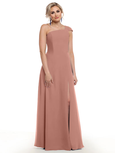 A woman models Avery Austin’s 80139 dress—a sleeveless, dusty rose pink gown with an asymmetrical neckline and thigh-high slit—against a plain white background.